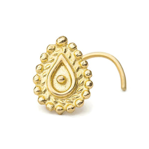 A gold-colored nose pin with a decorative design on it.