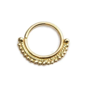 A gold-colored metal ring with a decorative design on the surface.