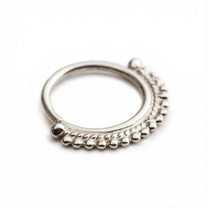 A silver ring with a decorative band of small, round beads around the edges.