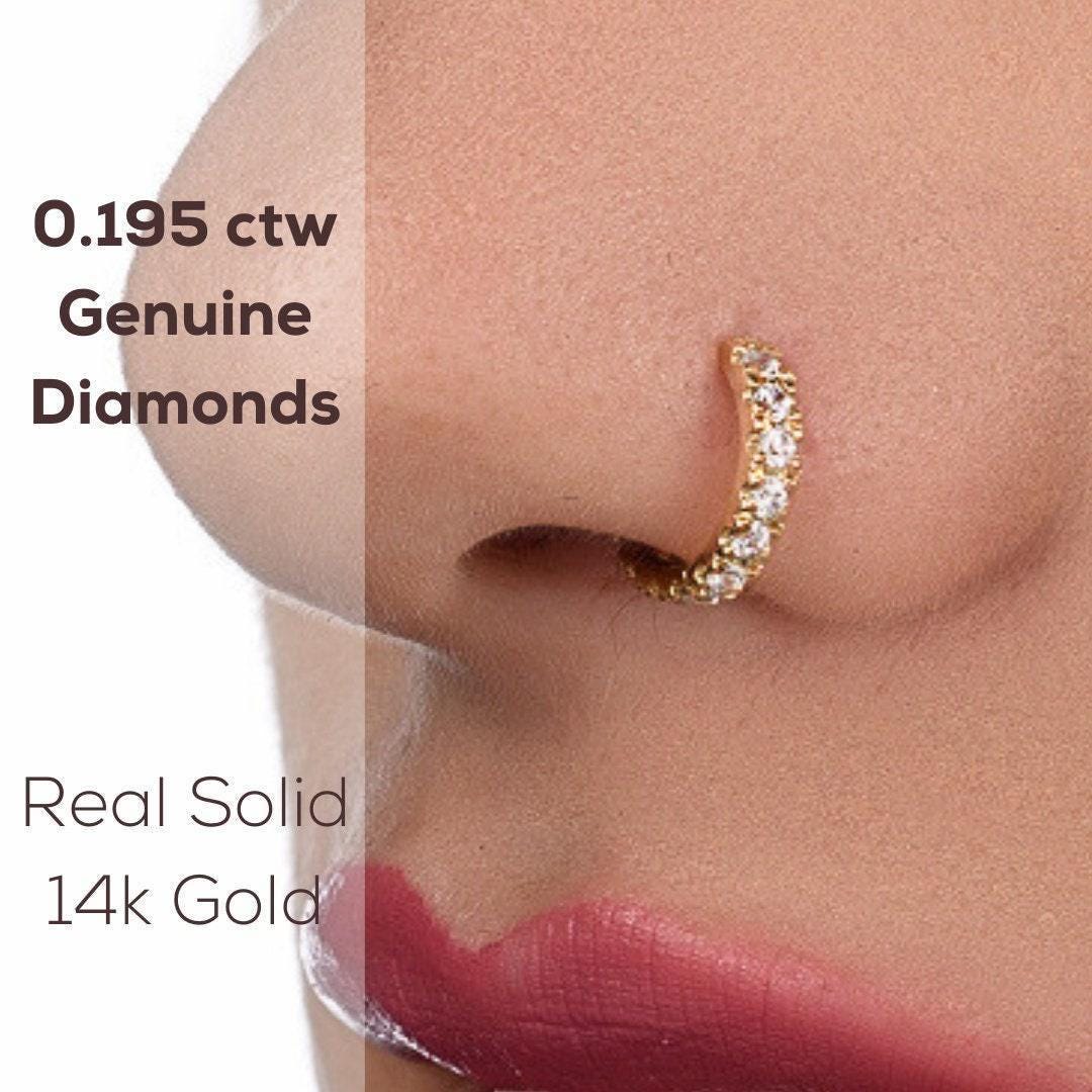 Diamond Nose Hoop: a close-up of a person's nose with a gold nose ring adorned with diamonds.
