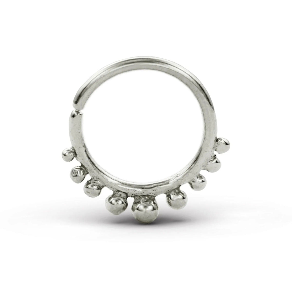 A silver-colored metal ring with a unique design, featuring a central loop and a row of small, round beads or stones protruding from the surface.
