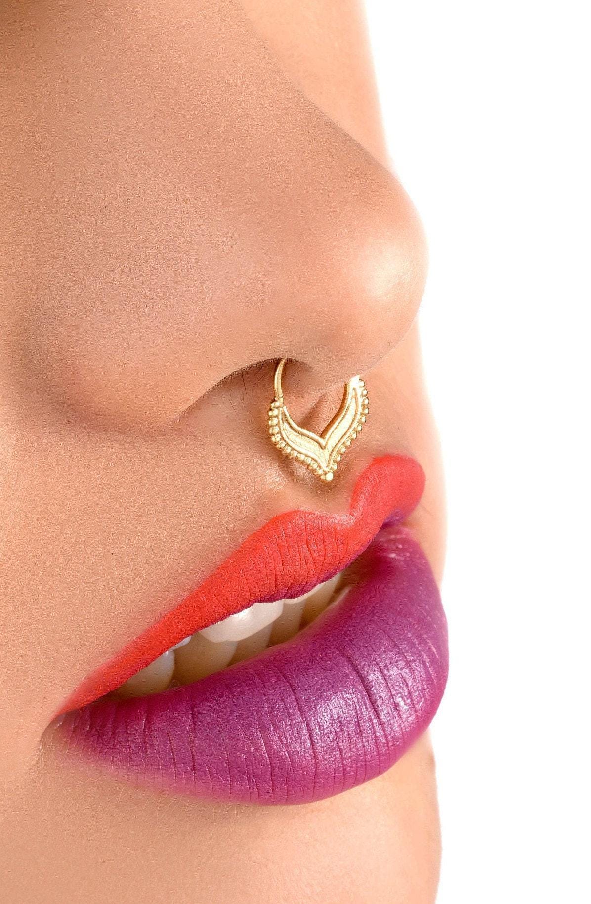 Beaded Gold Septum Ring: A close-up of a person's face, focusing on their lips and nose.