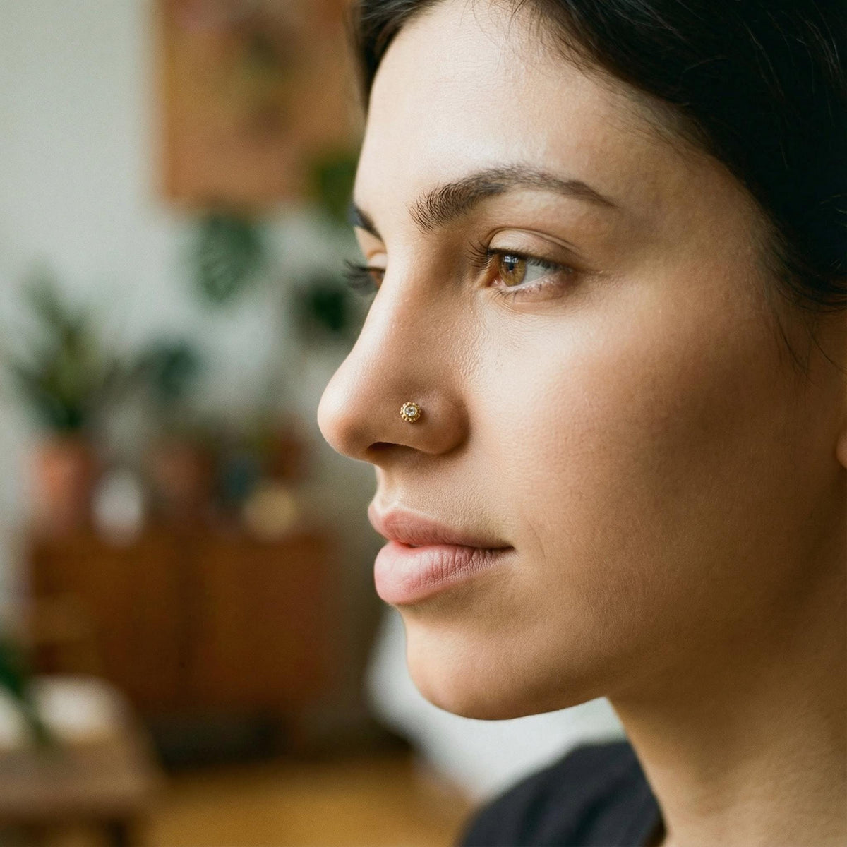 A gold nose ring with a unique diamond