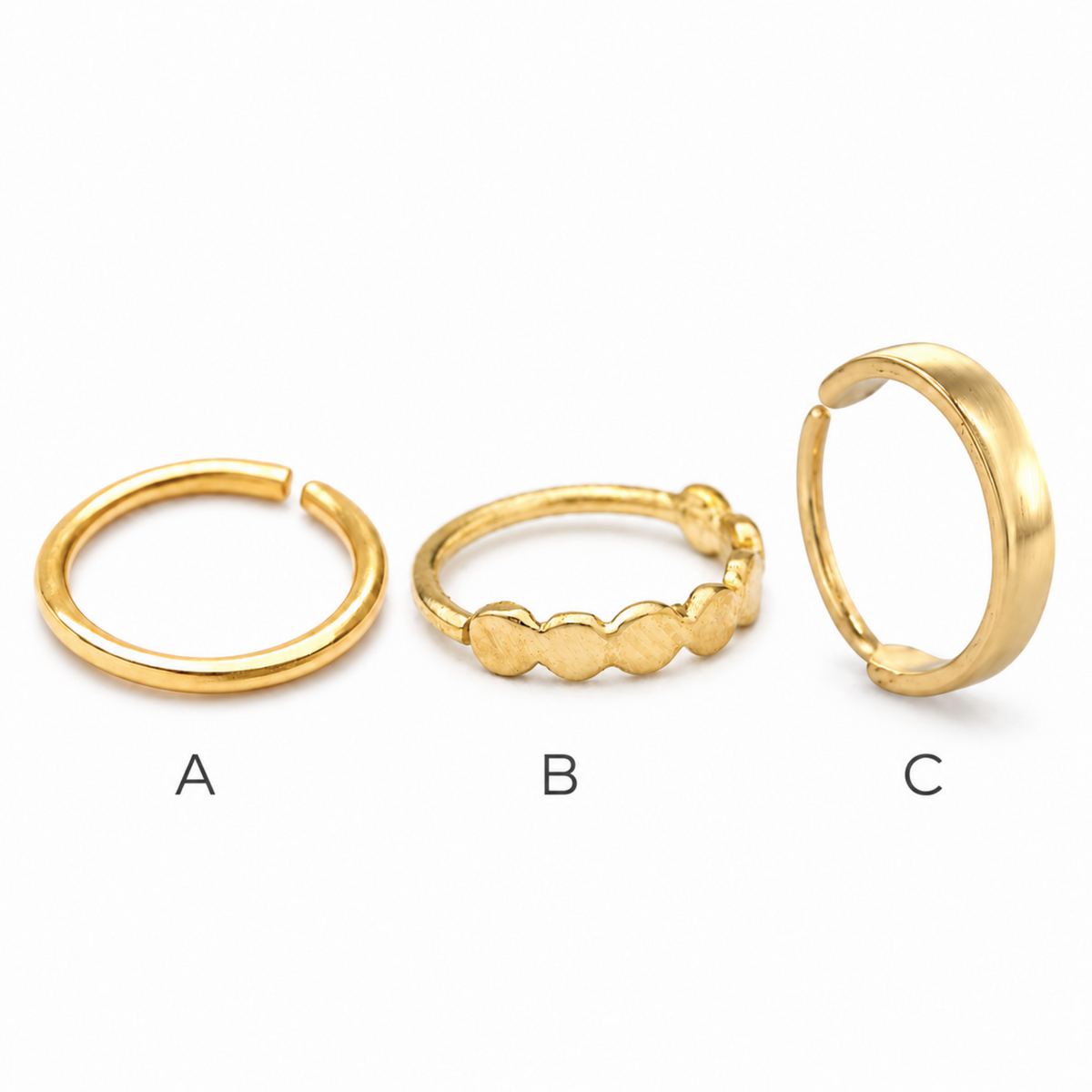 Three gold-colored rings are displayed in a row, each with a different design.