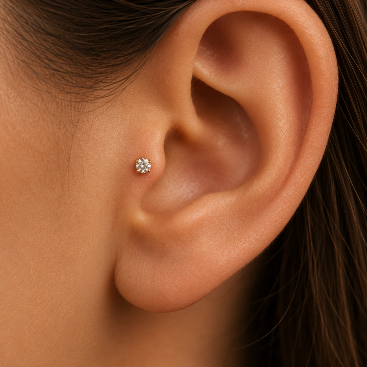 A close-up of a person's ear with a small diamond earring in the earlobe.