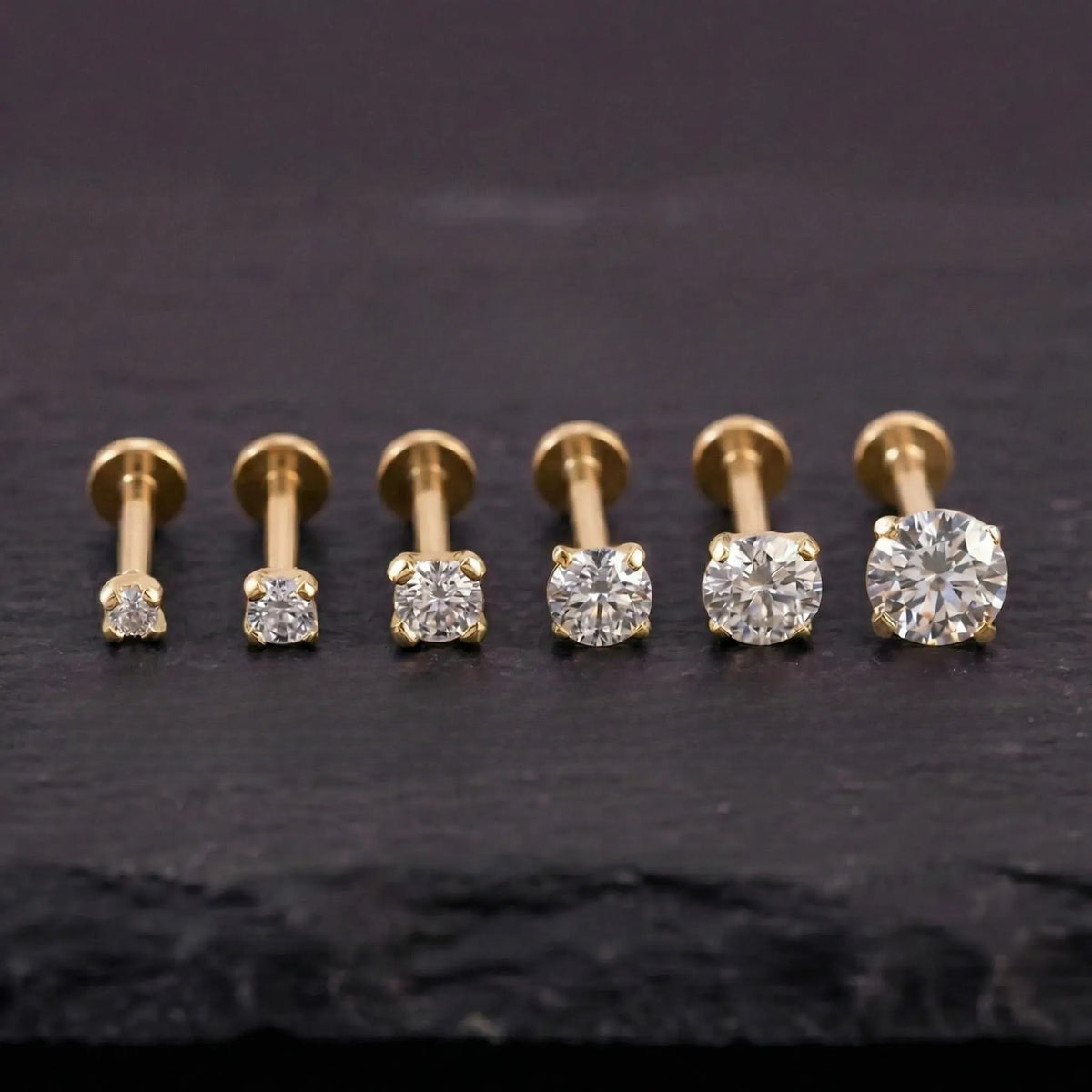 A collection of six gold-colored diamond-encrusted nose studs, each with a different size ranging from 1.5mm to 4mm.