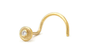 A gold-colored nose ring with a small diamond in the center.