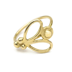 A gold-colored ring with a decorative design featuring a butterfly-like motif.
