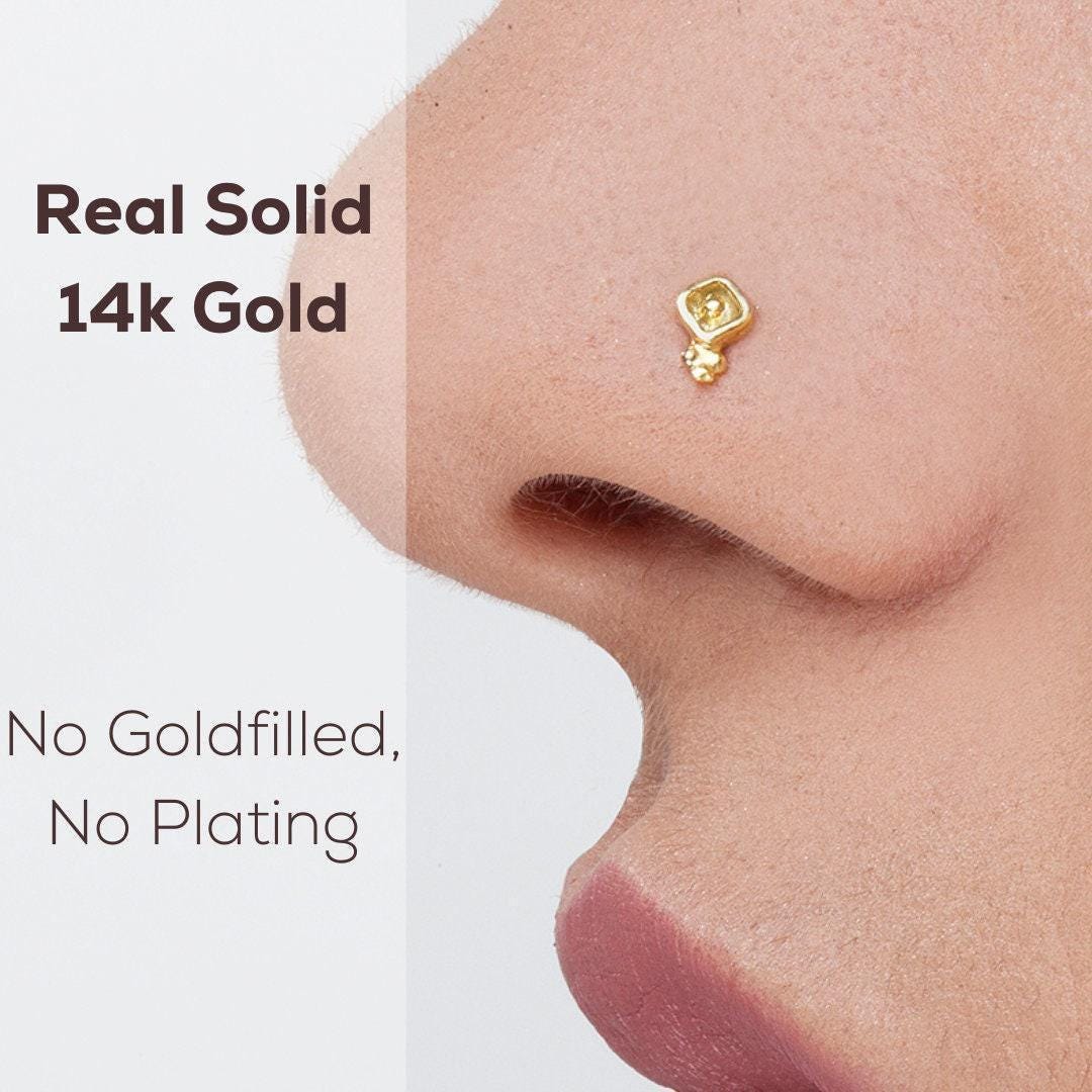 a close-up of a person's nose with a small gold nose stud.