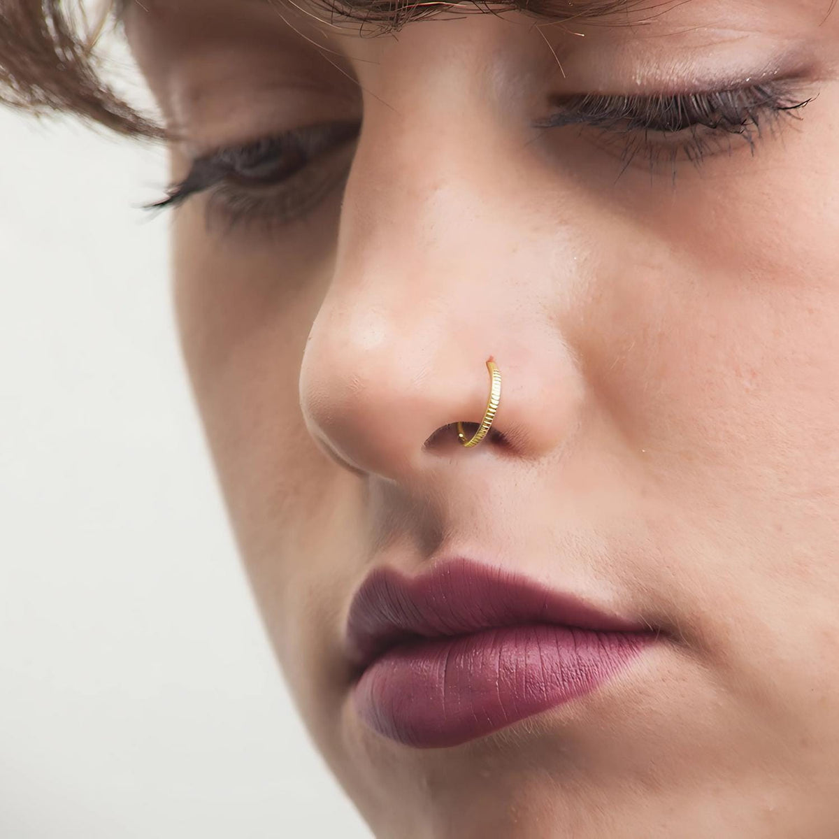 Nose Hoop Ring: A close-up of a person's face, focusing on their nose and lips.