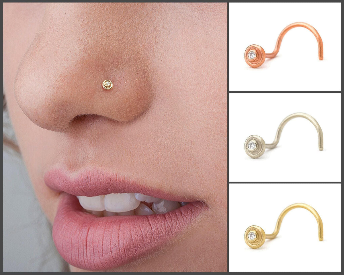 A close-up of a person's face, focusing on their nose and lips. There are three different nose piercings shown, each with a small diamond in the center.