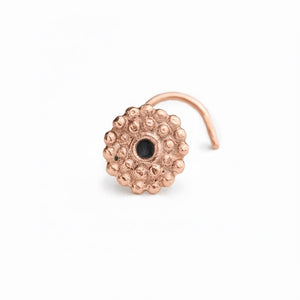 A copper-colored, textured nose ring with a small black center hole is shown against a white background.