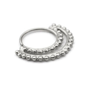 A silver-colored metal ring with a row of small, round beads or stones arranged around the edge.