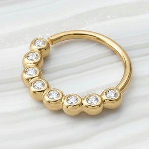 Diamond Nose Hoop: a yellow gold ring with a row of small diamonds set in it.