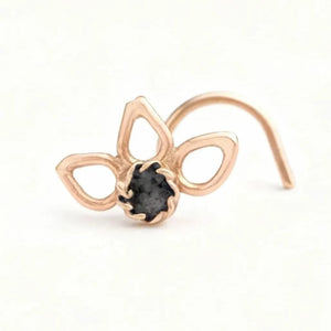 A gold-colored nose ring with a small black gemstone in the center.