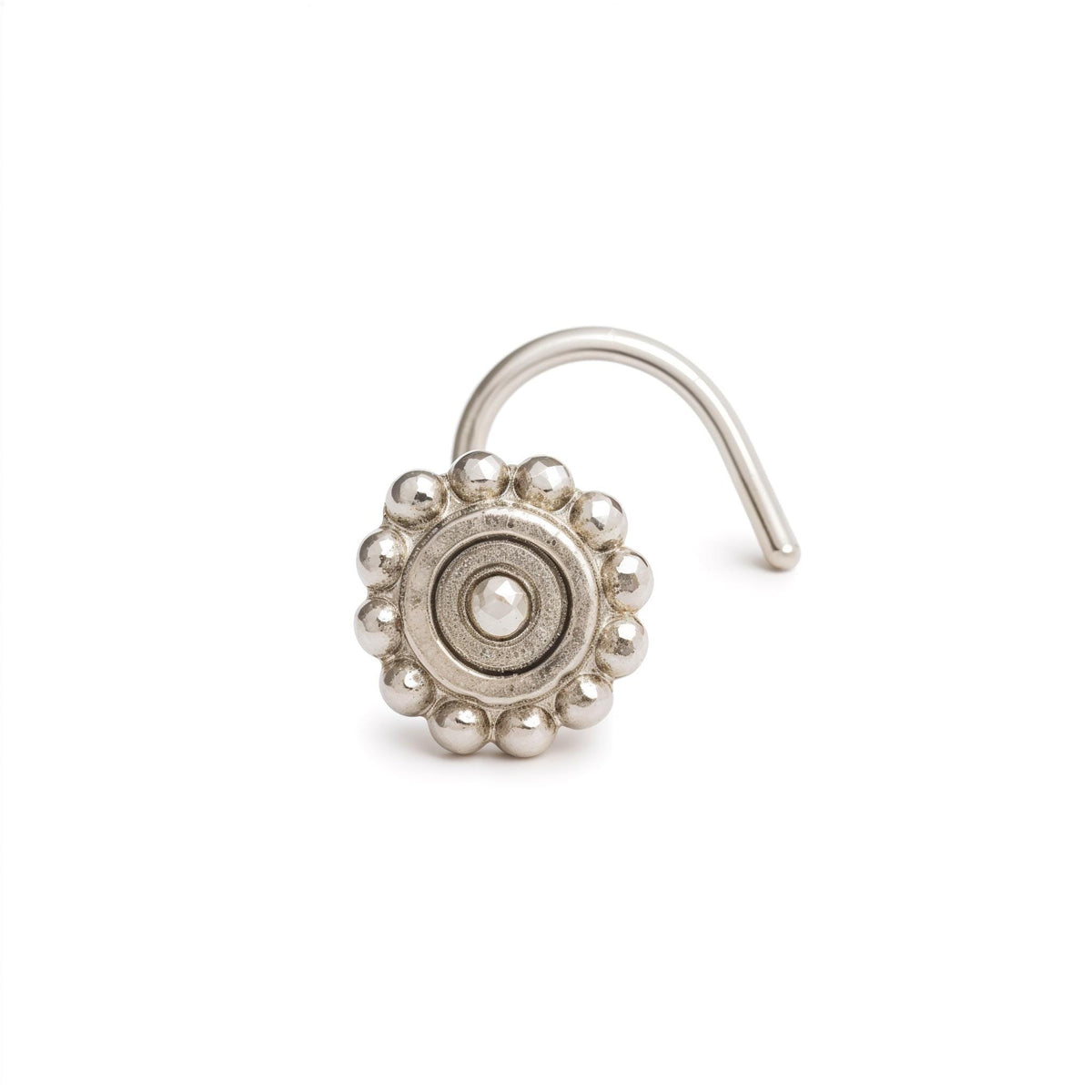 A silver-colored metal nose ring with a decorative design on it.