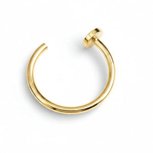 A gold-colored metal ring with a small circular piece on top.