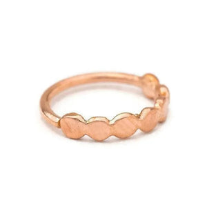 A rose gold ring with a row of small, round-shaped stones or beads.
