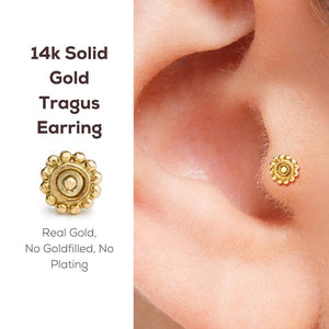 Sun Tragus Stud Earring: a close-up of a gold earring with a flower-like design, placed in an ear. The text next to the earring provides information about the earring, including its 14k gold material, solid gold construction, and the fact that it is a real gold earring without any fillings or plating.