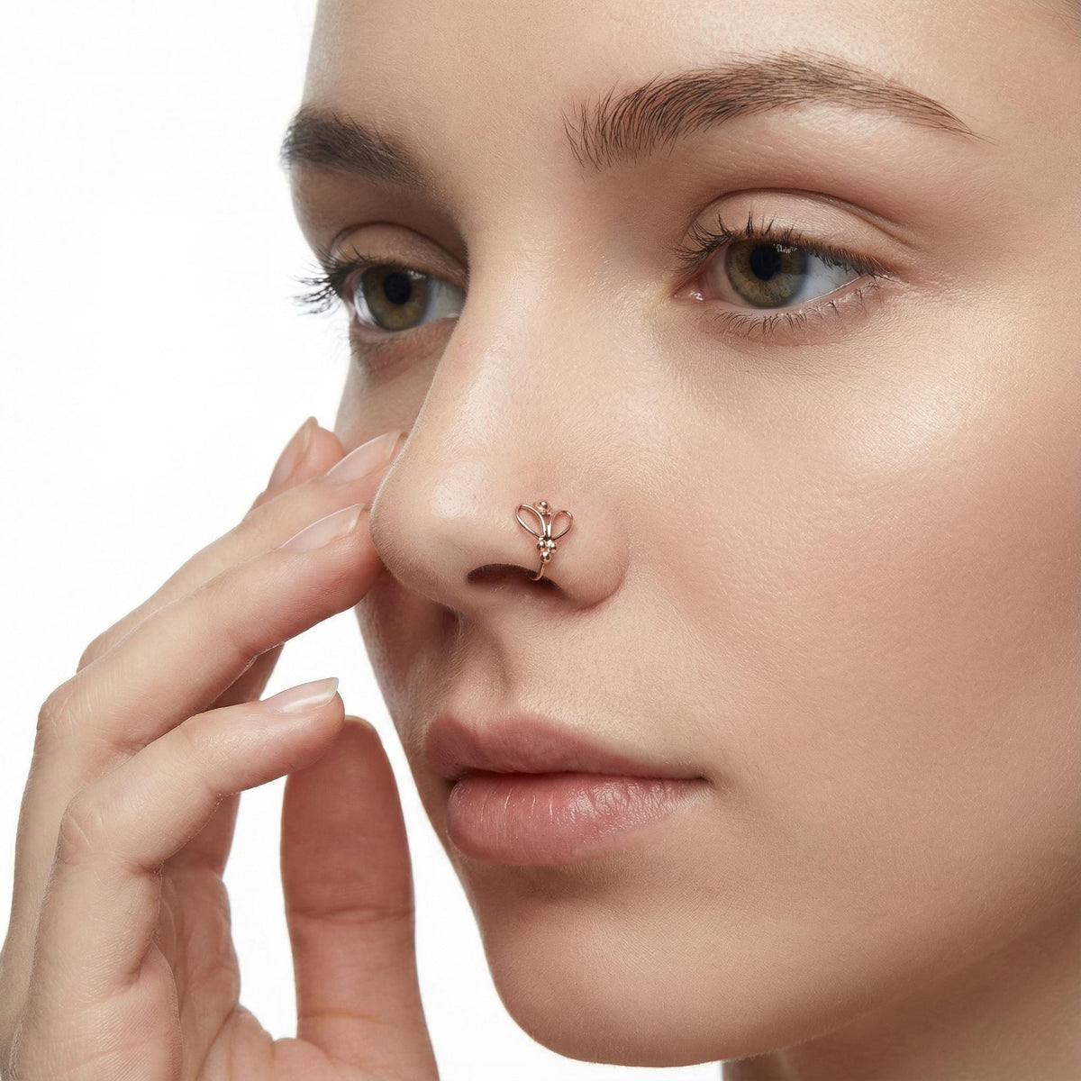 A close-up of a woman's face, focusing on her nose and fingers, with a nose ring visible.