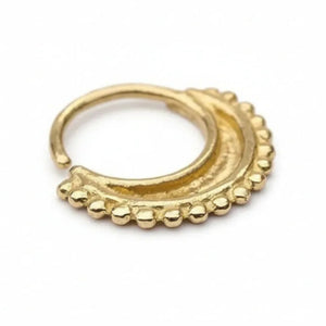 A gold-colored metal earring with a decorative design, featuring a curved shape and small, round beads or stones along the edge.