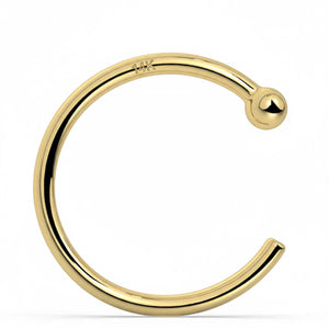 A gold-colored metal ring with a small ball at the end, stamped 14k.