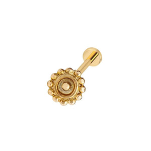A gold-colored metal earring with a decorative flower-like design on the center.