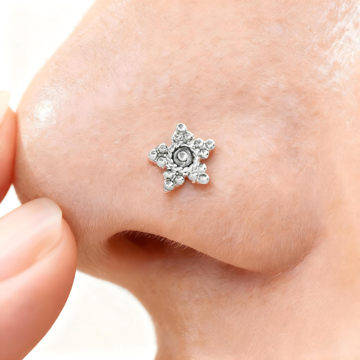 Star Nose Stud: A close-up of a person's nose with a small, sparkling star-shaped nose stud.