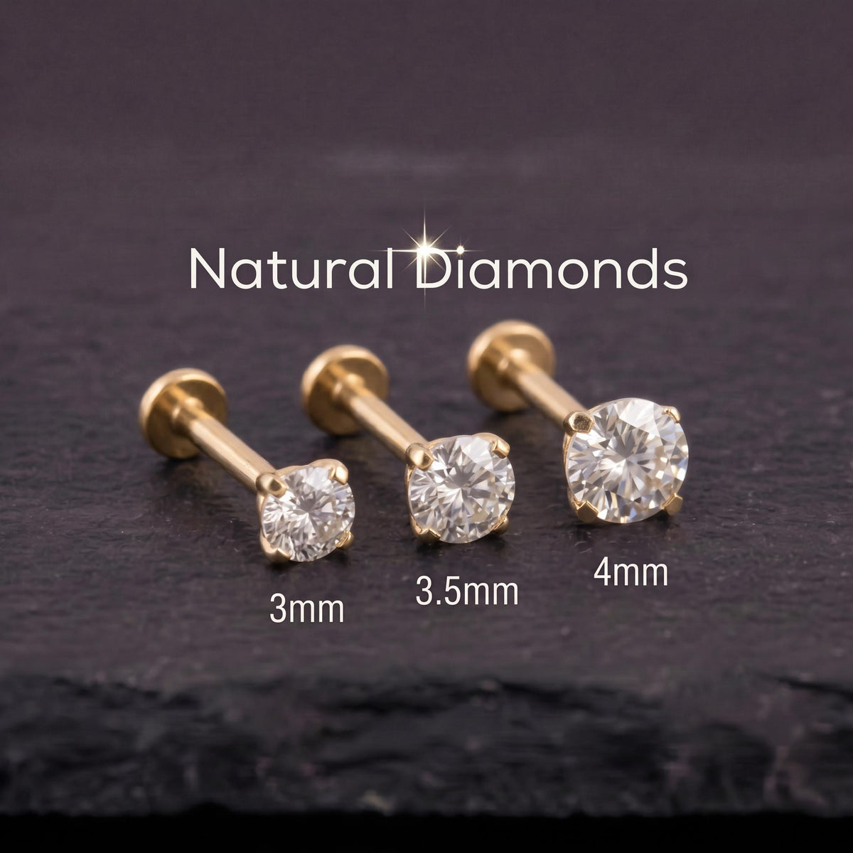 three natural diamonds of different sizes, each with a corresponding gold-colored metal piercing.