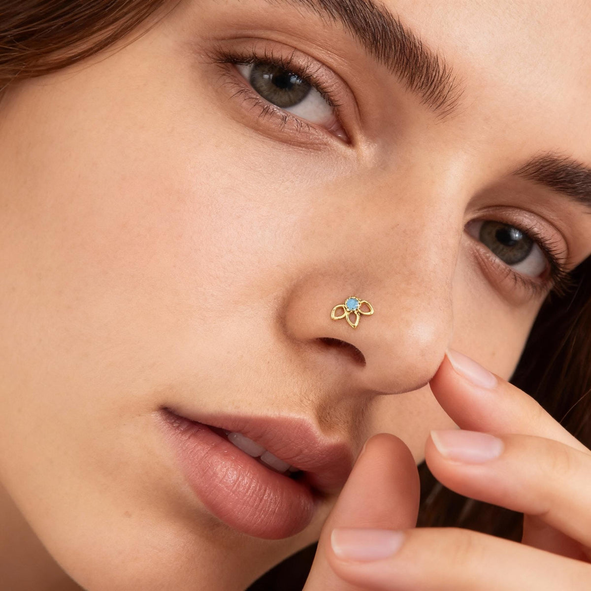 A close-up of a woman's face, focusing on her nose and fingers.
