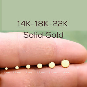 Disk Nose Stud: A close-up image of a person's hand holding a series of gold-colored stud earrings, each with a different size ranging from 1.5 mm to 6 mm.
