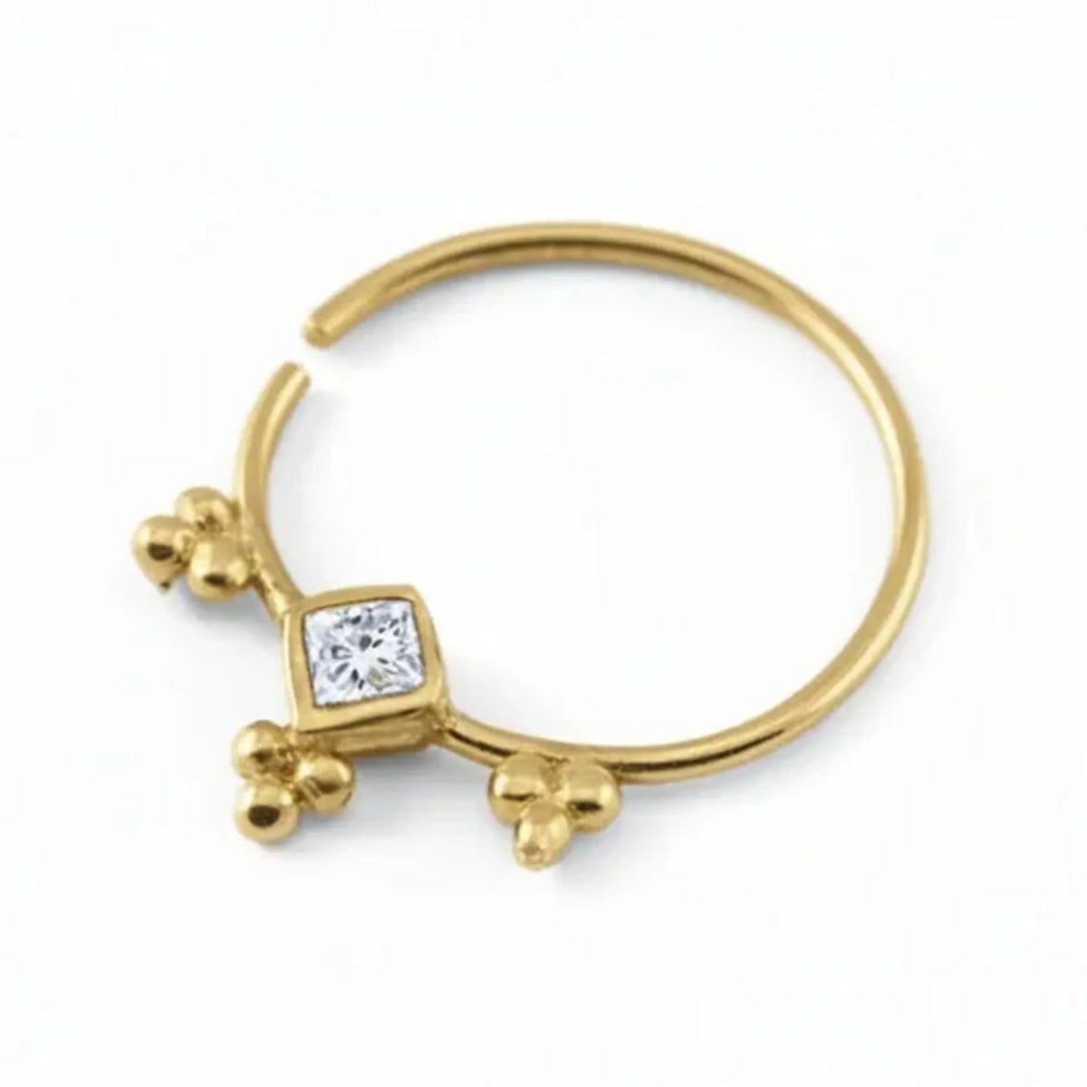A gold-colored nose ring with a diamond-like gemstone set in the center.