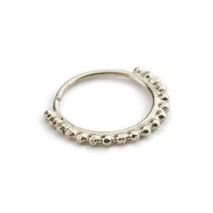 A silver-colored metal ring with a row of small, round beads or stones along the edge.