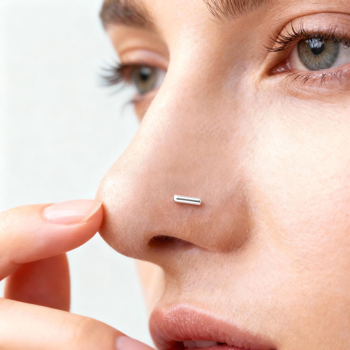 A close-up of a person's face, focusing on their nose and fingers.
