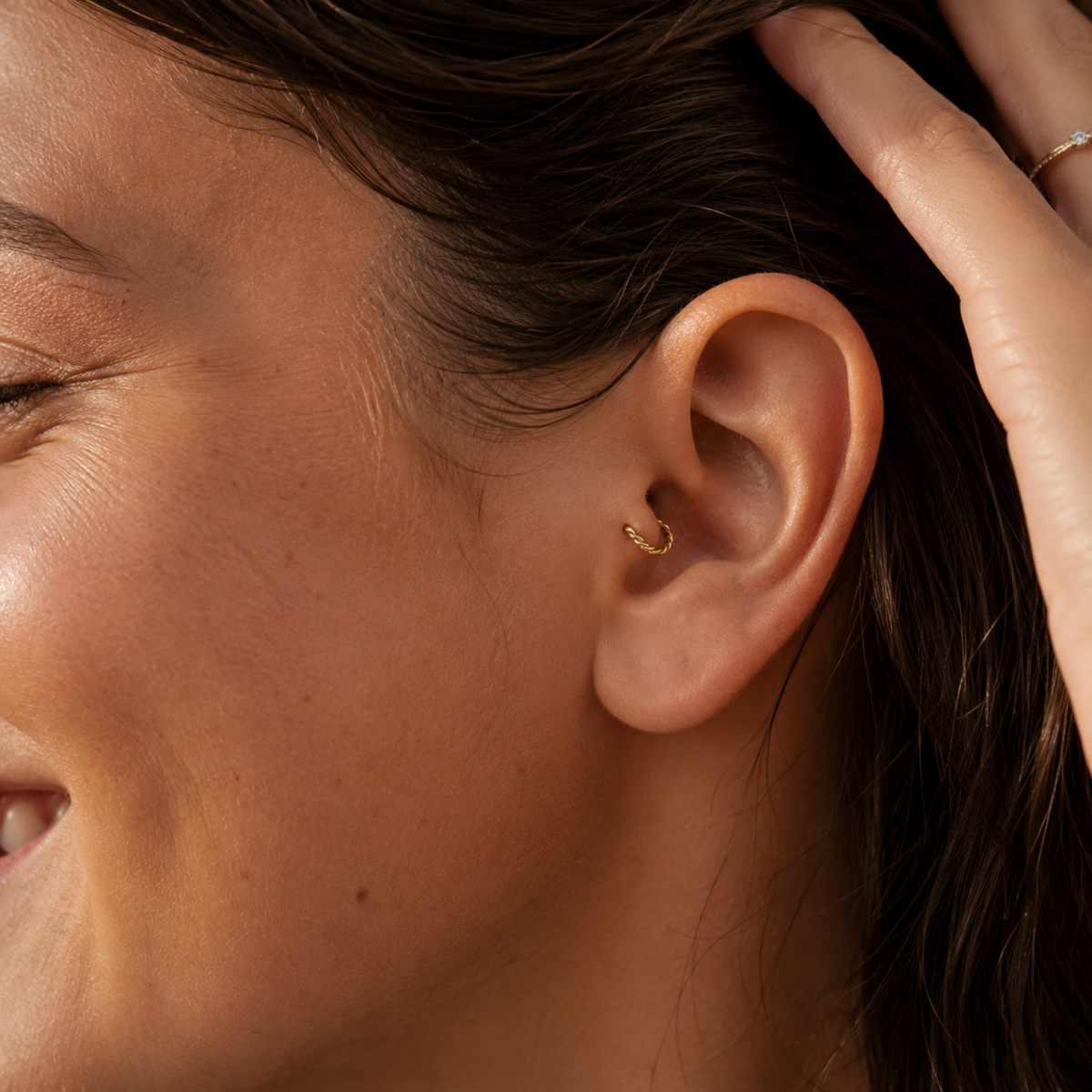 A close-up of a person's face, focusing on their ear and smiling expression.