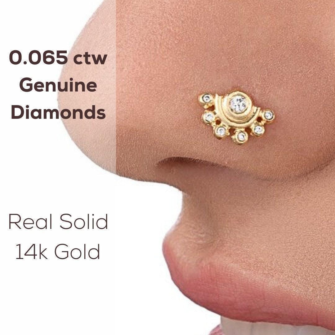 a close-up of a person's nose with a gold nose ring adorned with genuine diamonds.