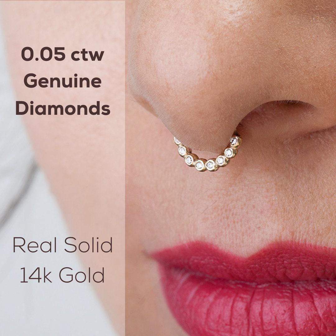 Diamond Septum Ring: a close-up of a person's nose and lips wearing a nose ring with a series of small diamonds set in it.