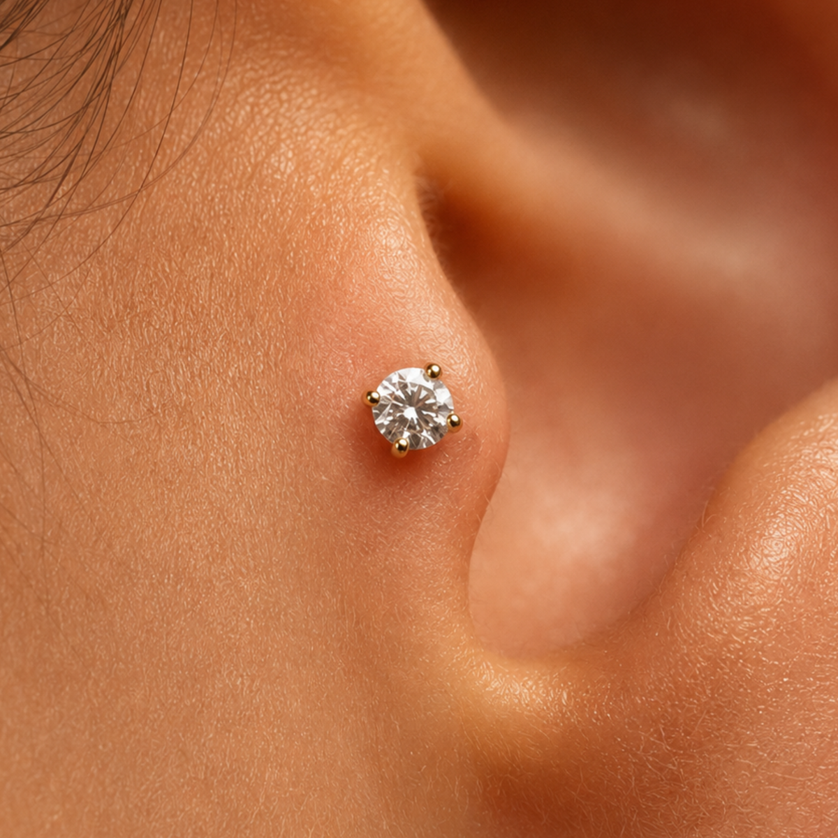 A close-up of a person's ear with a small diamond earring inserted in the earlobe.