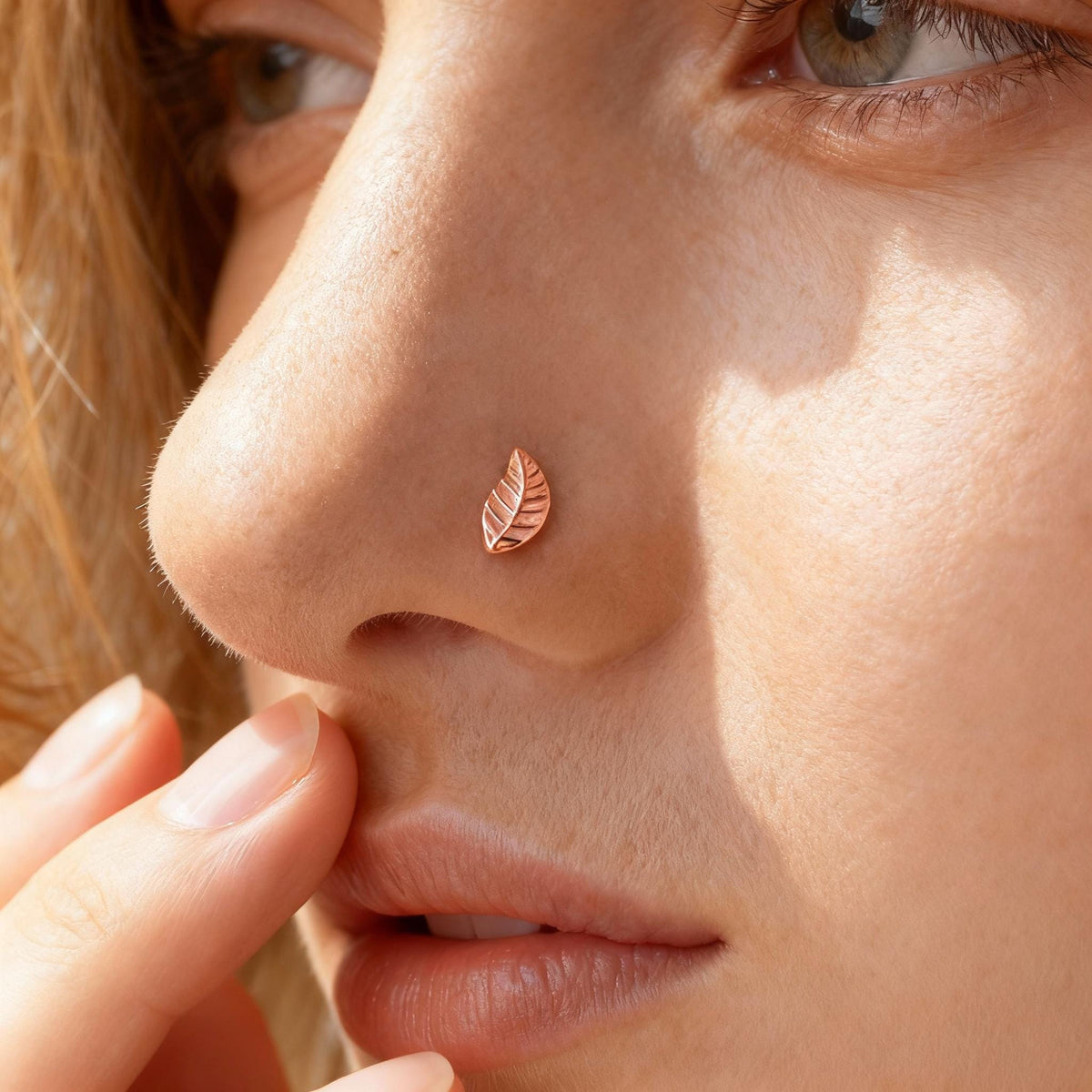 A close-up of a person's face, focusing on their nose and fingers.