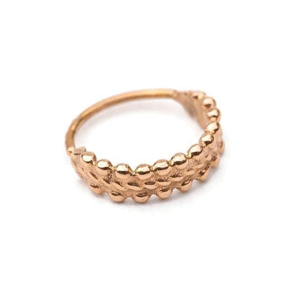 A gold-colored ring with a textured, embossed design.
