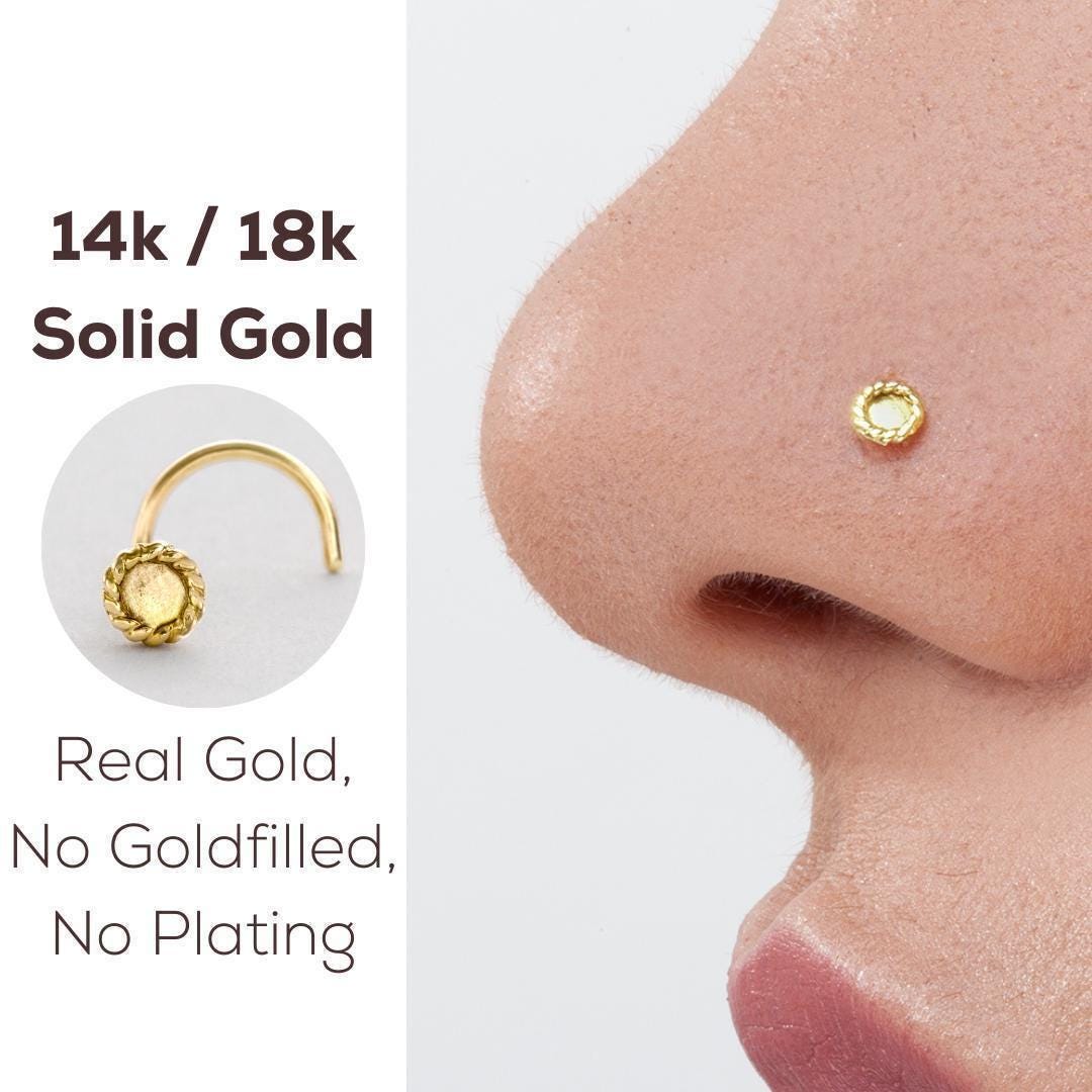 a close-up of a gold nose stud on a person's nose, accompanied by text describing the nose stud as a 14k gold solid gold nose ring.