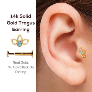 Tragus Piercing Stud: a 14k gold earring with a blue gemstone, placed in an ear. The earring is described as a real gold earring, meaning it is made of real gold and does not have any fillings or plating.
