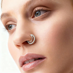 A close-up of a woman's face, focusing on her nose and lips. She has a nose ring and is looking directly at the camera.