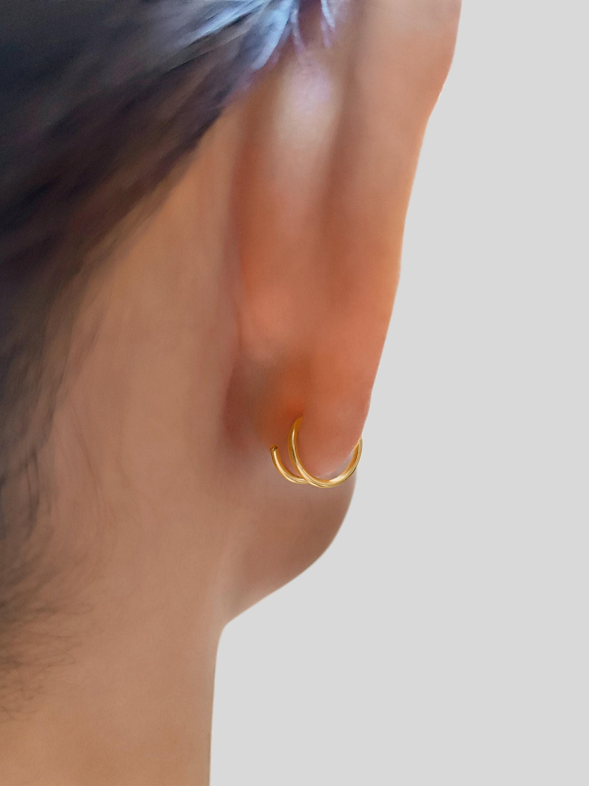 a close-up view of a person's ear, focusing on the earring and the person's hair.
