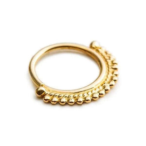 A gold-colored ring with a decorative element on the side.