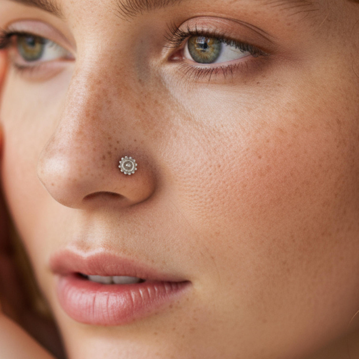 A close-up of a woman's face, focusing on her nose and the surrounding skin.
