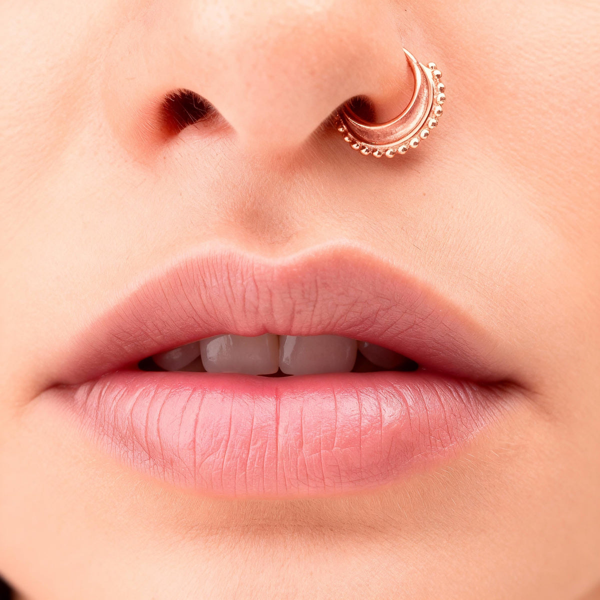 A close-up of a person's lips with a nose ring, showcasing the delicate details of the facial features.