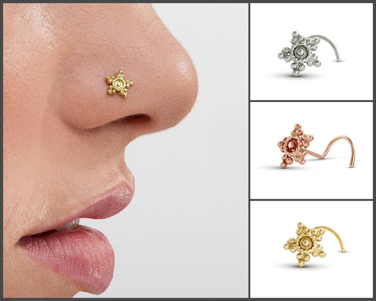 A close-up of a person's nose with a decorative nose ring featuring a star-shaped design.