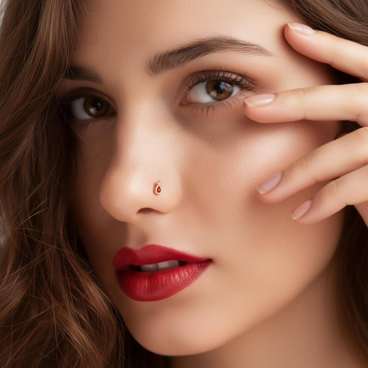 A close-up portrait of a woman with long brown hair, wearing red lipstick and a nose stud.