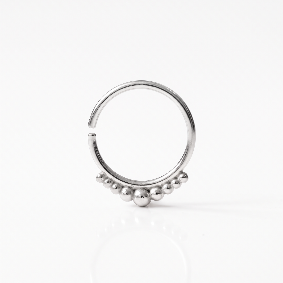 A silver-colored metal ring with a row of small, round beads or stones on the front.